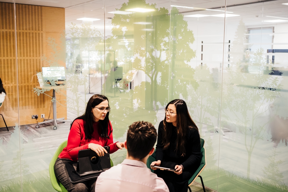 Three people discussing in a meeting