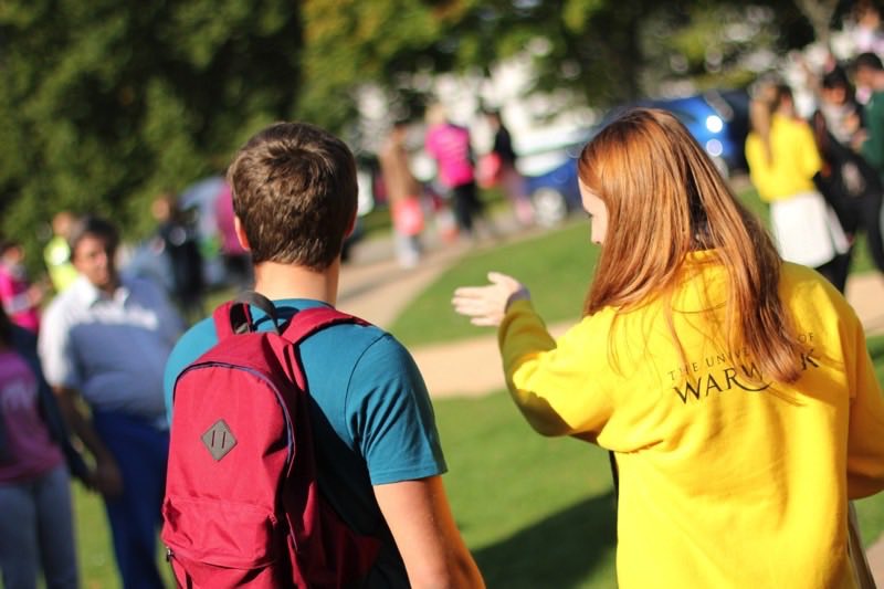 A Warwick welcome ambassador supporting a visitor