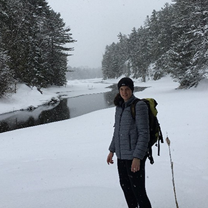 Greta Delfino in hiking gear by a snowy river