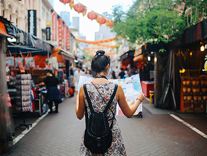 A young person looks at a map on a steet