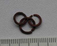 Image of one of the chainmail links - Having the appearance of copper. Credit: Mark Dowsett with permission from the Mary Rose Trust