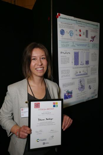 Fabienne shows off her Silver certificate next to her winning poster.