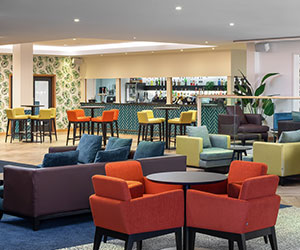 Colourful seating in a large, bright lounge with unlimited refreshments at Scarman lounge.