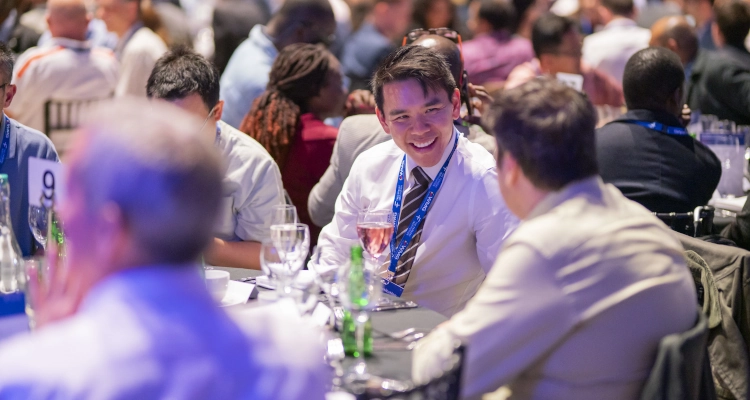 A group of people talking at a conference dining table and smiling
