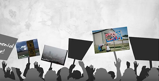 screenshot from an animated video showing people waving placards