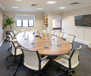 Creative meeting spaces with large boardroom table and seating and monitor on the wall