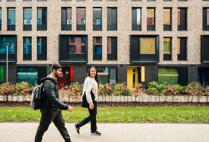 Two students walk past the accommodation block at Cryfield