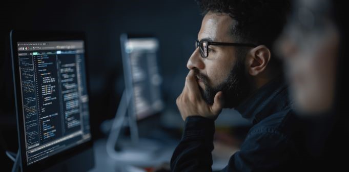 A man concentrating on work on his computer monitor