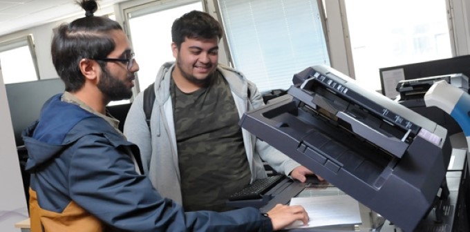 Students using a printer to scan in a document