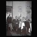 Group in a small dining room, Petronella at front