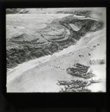 The first Spanish landing on Cebadilla Beach on Sept. 8th 1925, an air view showing scouts climbing the sandhills, and troops disembarking from the boats, on two of which may be seen turreted tanks.