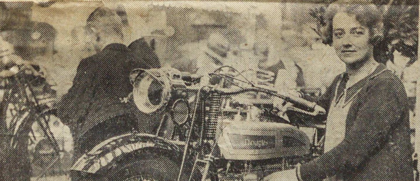 Press cutting photograph of a woman sitting by a motorbike at a bike show