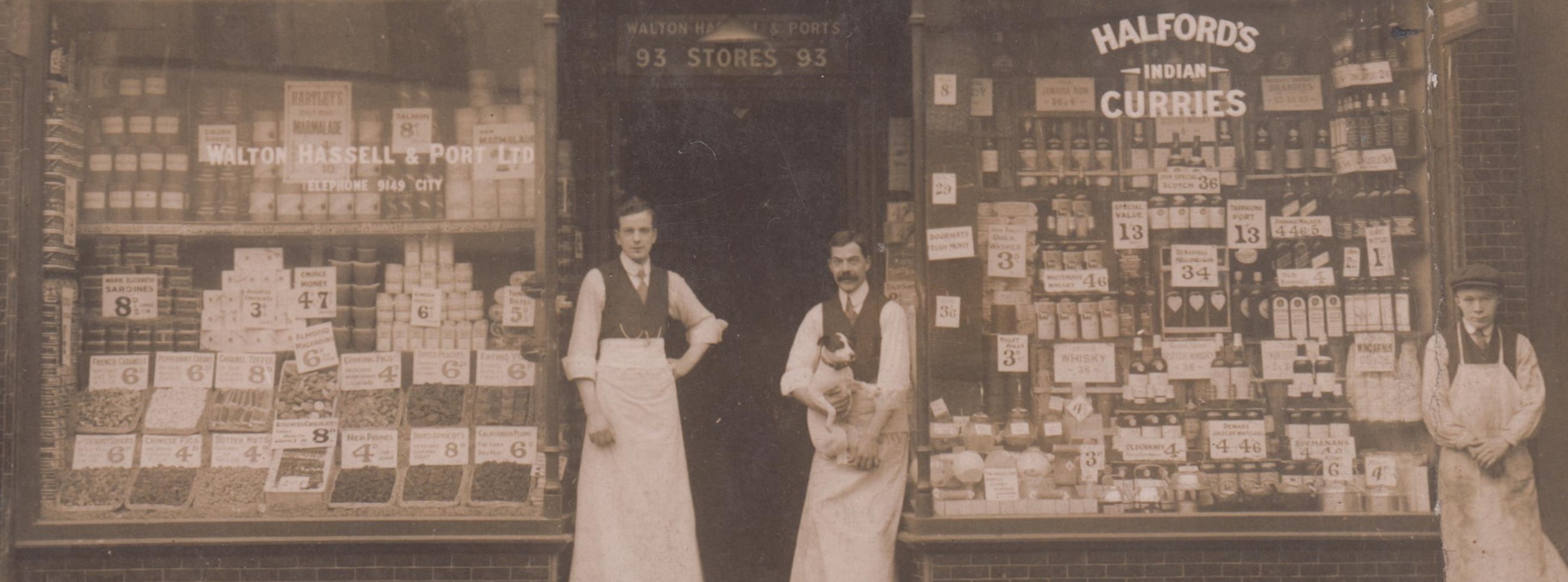 Front of a grocery shop, with staff standing outside