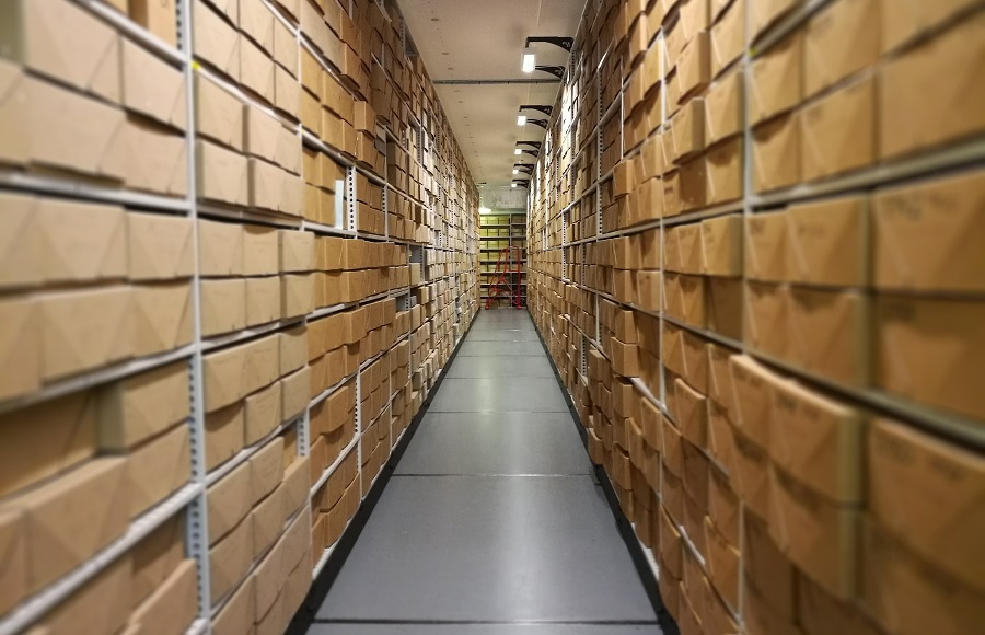 Image of one of the Modern Records Centre's strongrooms, looking along a long row of shelving filled with boxes.