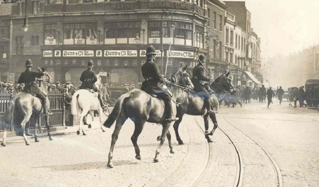 Police on horseback, chasing protestors.