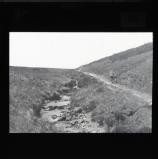 Cyclist on Nant Rhyd Wilym [Rhydwilym] Pass in its 1920s rough state (Wayfarer's Pass)