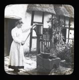 Woman in white frock pumping water