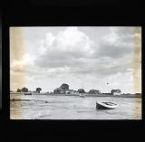 Rowboat at low tide, houses in distance