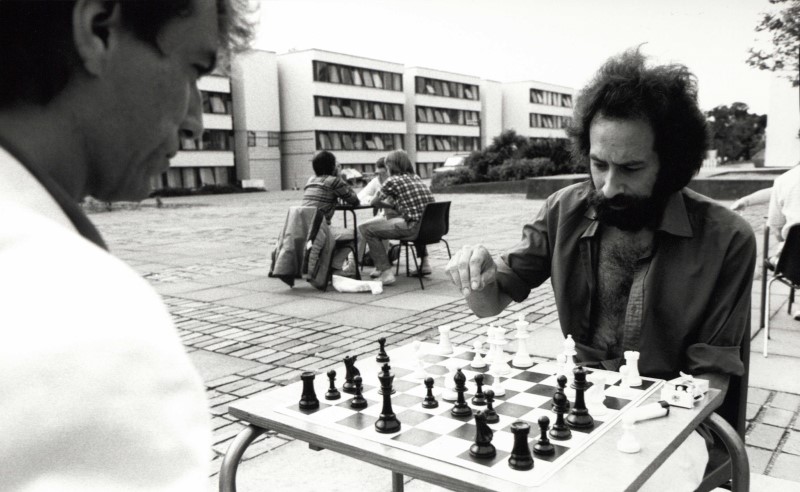 Two men sitting outside, playing chess. The photograph was taken at the University of Warwick in the 1960s.