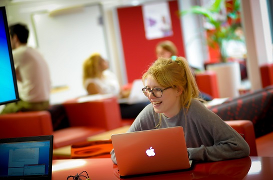 Student with laptop inside Postgrad Hub
