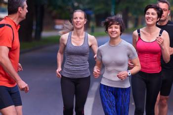 Four joggers on campus led by an instructor