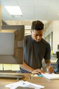 man writing on paper