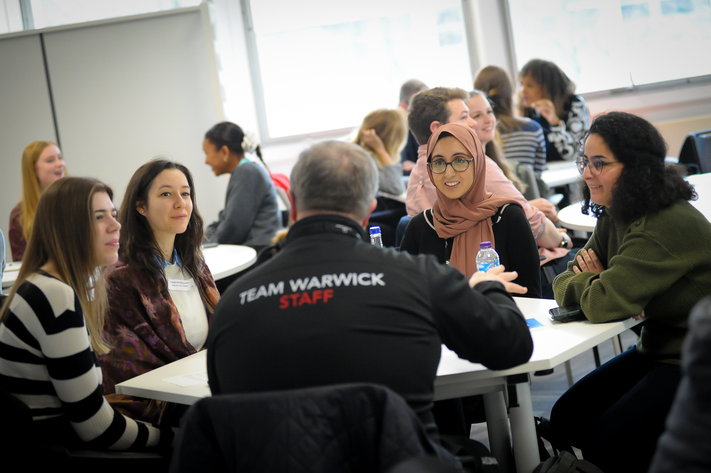 A group of people sitting around a circular table to represent courses and programmes