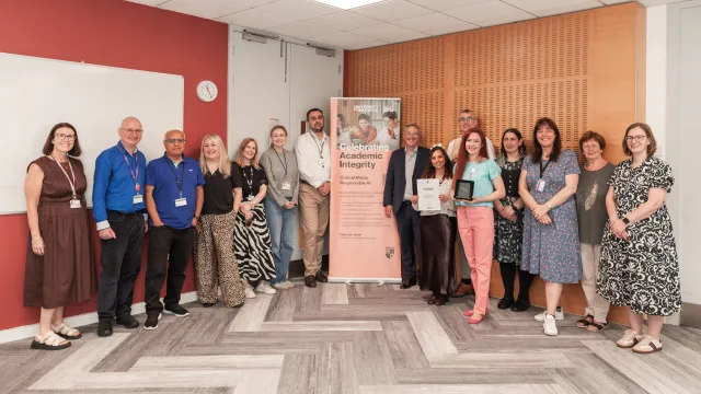 A group of people are holding an award all smiling at the camera.