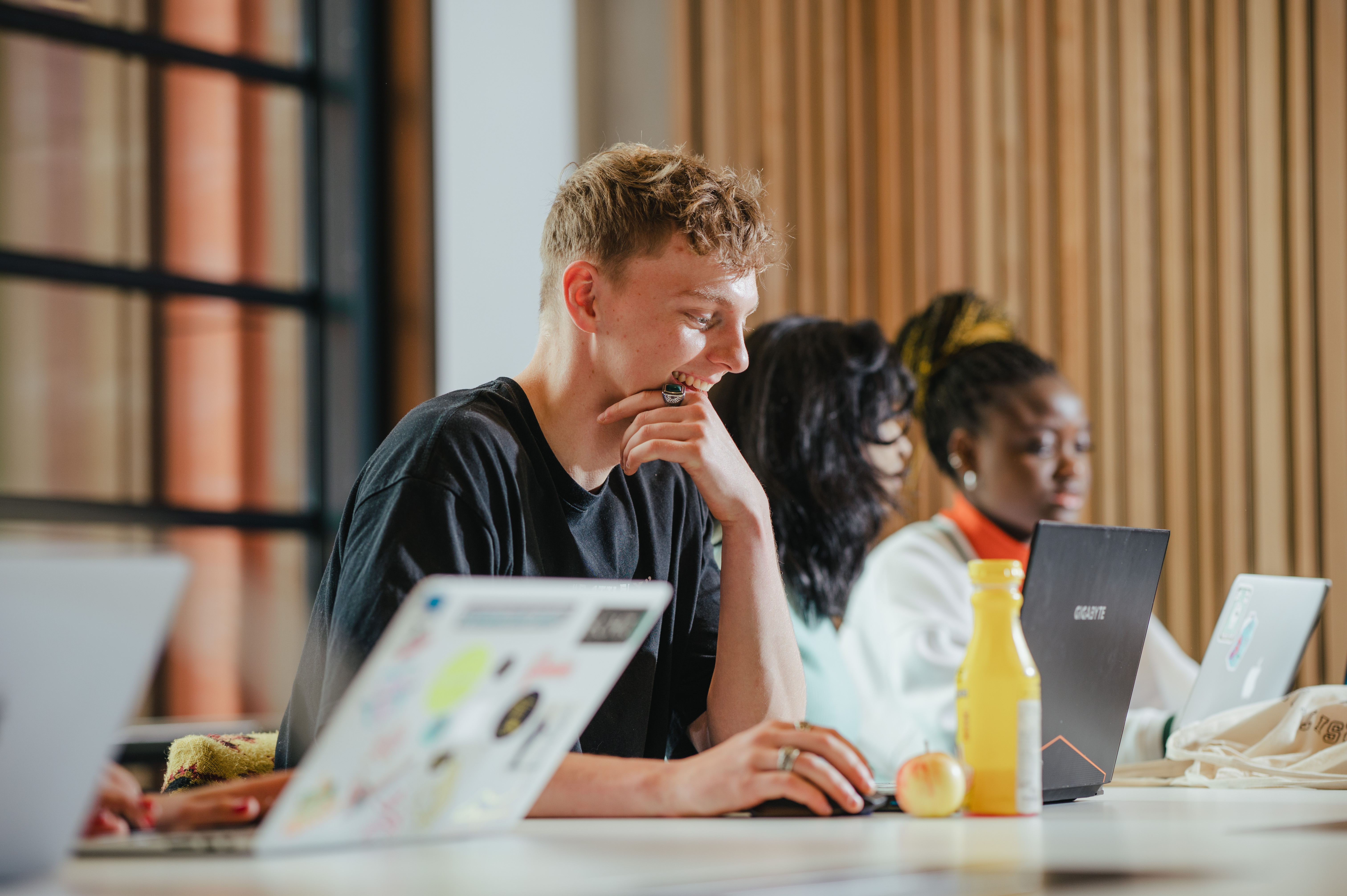 Two students are working seperately at their laptops in one of the Faculty of Arts Building's collaboration spaces