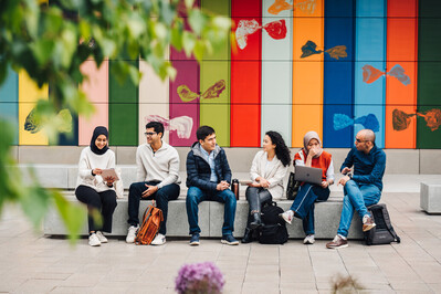 Students sitting in a row outdoors