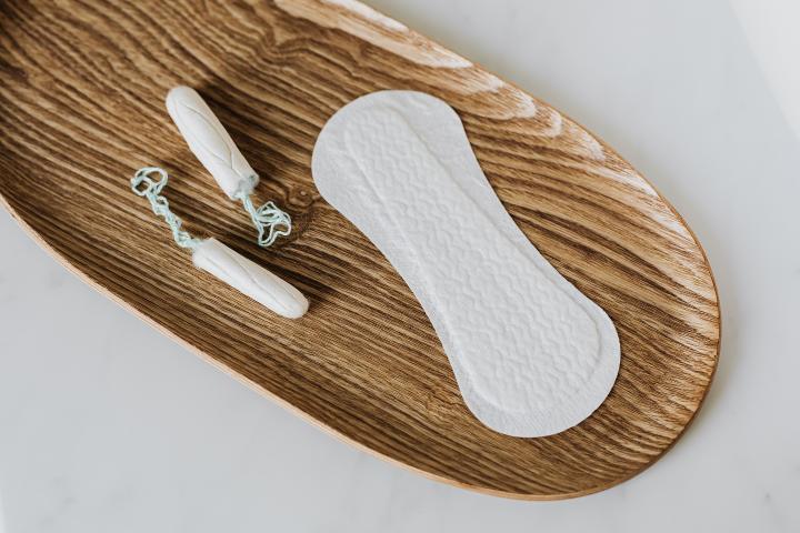 period pads and tampons on a bamboo tray