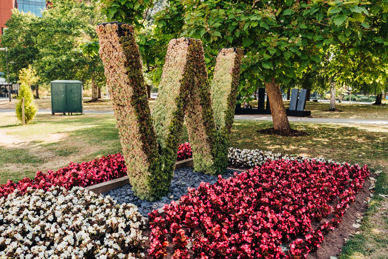 Warwick grenery in the shape of a W surrounded by flowers