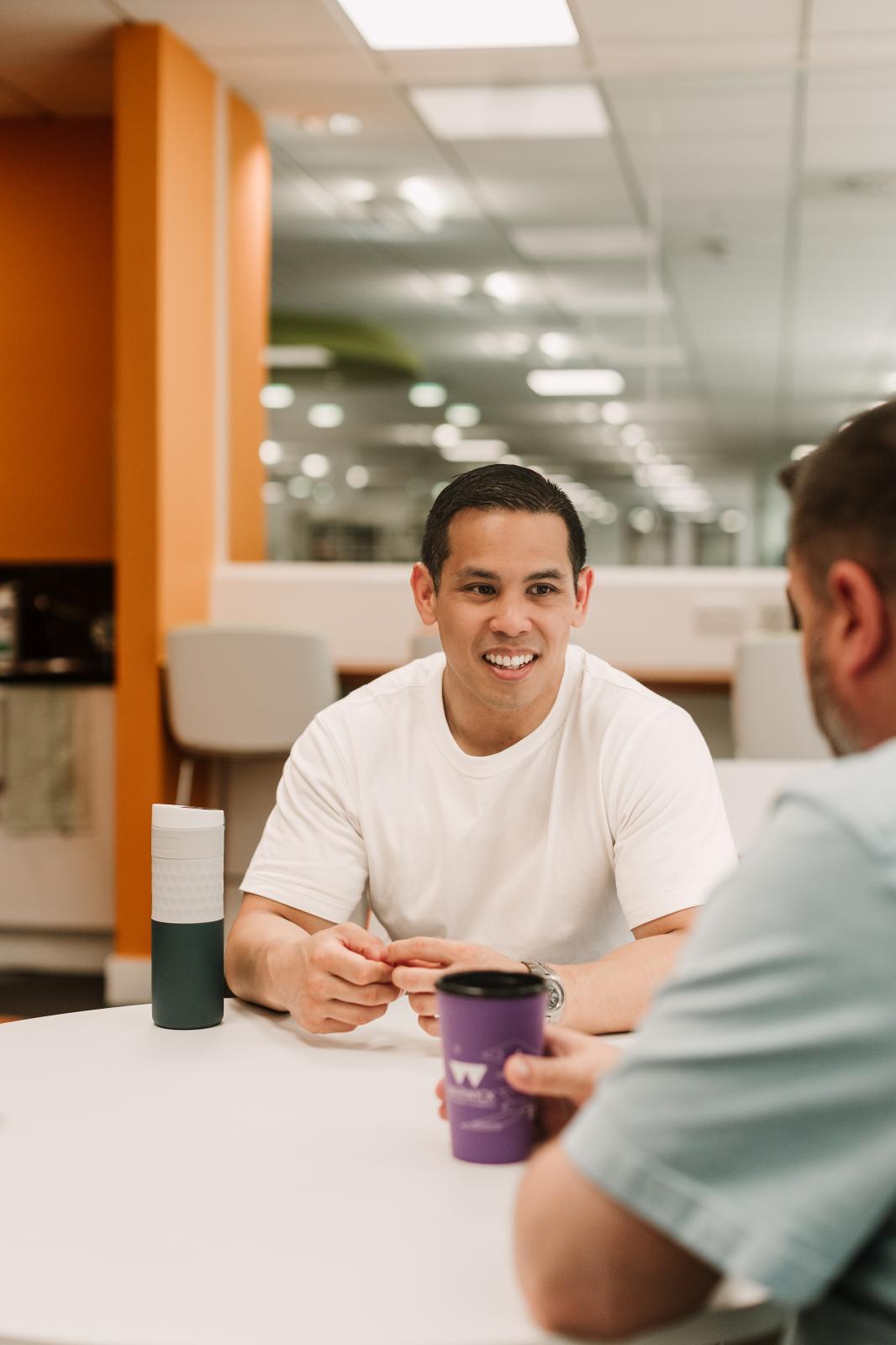 Two colleagues enjoying a coffee in staff kitchen