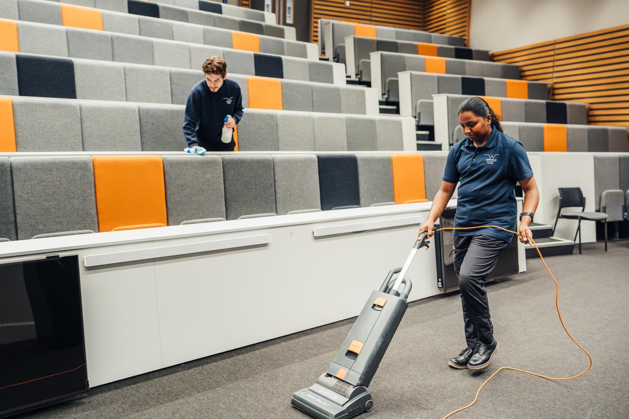 Estates members of staff keeping lecture theatre clean