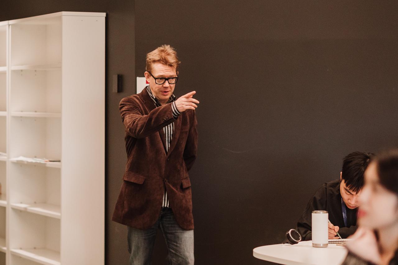 Lecturer pointing in class of students