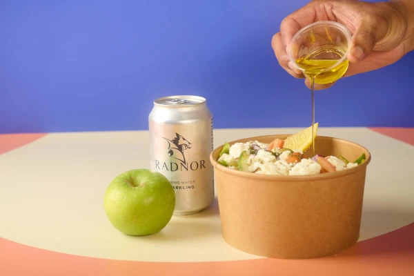 A salad bowl, apple and canned water