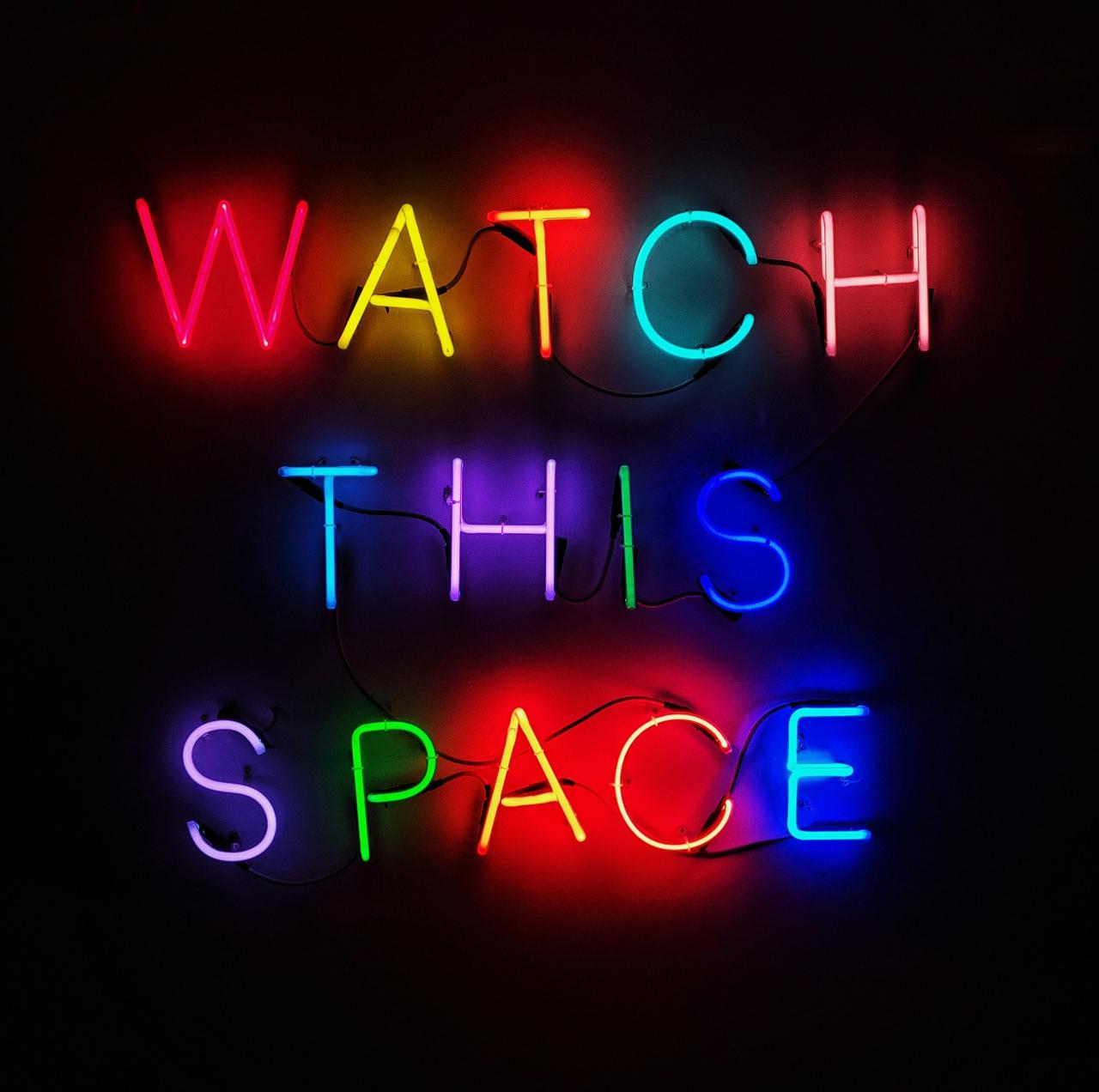 neon sign reads watch this space