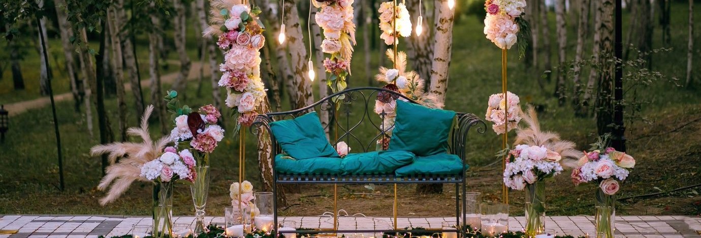 A bench surrounded by flowers and lights