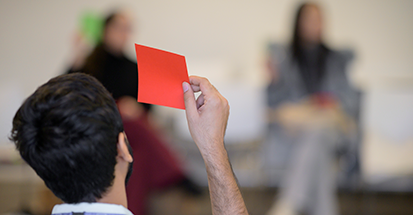 A person holding up a post it note