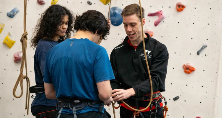 indoor climbers adjusting their harness and rope