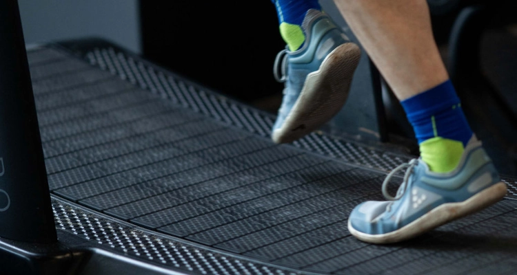 A close up of a persons shoes on a treadmill