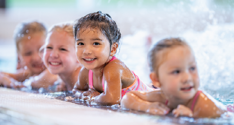 A group of children learn how to swim.