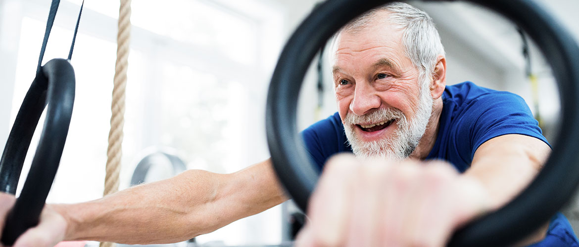 Man smiling whilst using gym equipment