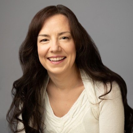 Image of a woman in a white top with long brown hair on a grey background