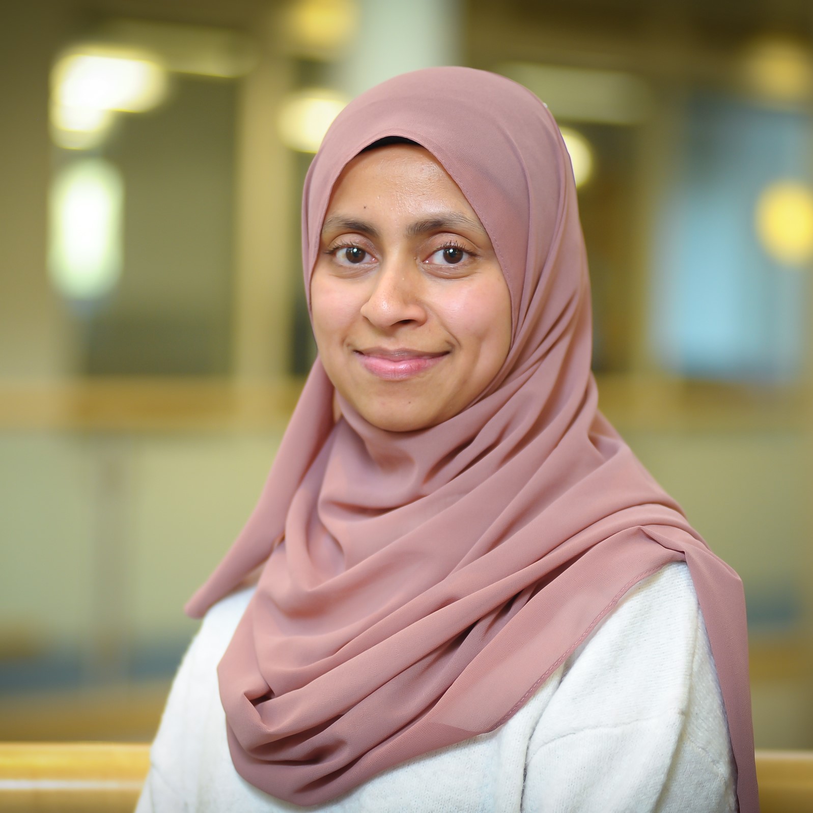Image of a woman in a light pink hijab on a blurred background