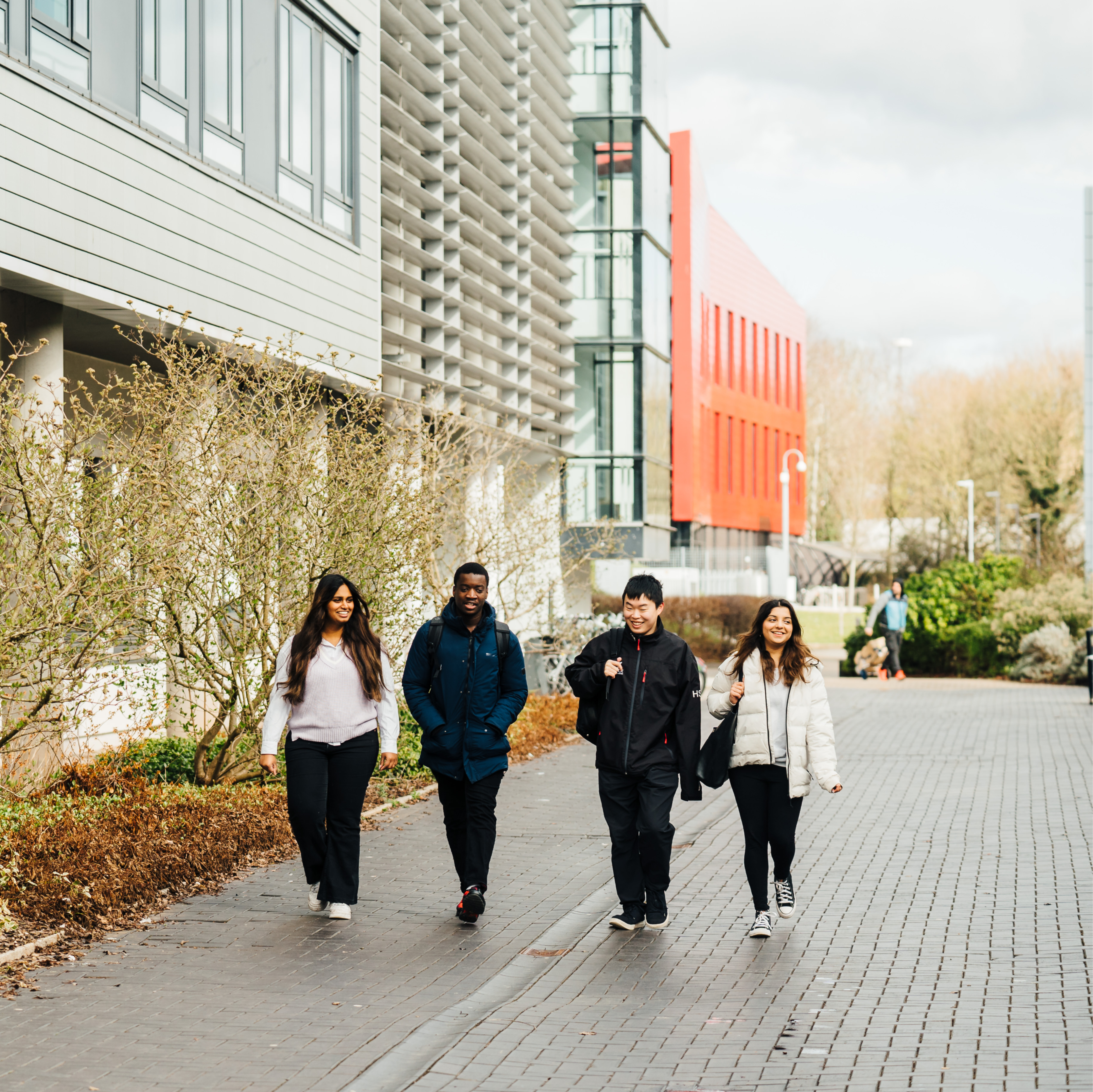 4 students walking through campus