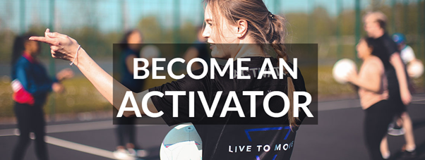 Picture of a student with a ball, in the background blurre dout students are passing balls around on an outdoor court.