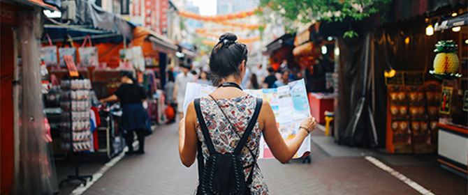 A woman looking at a map in a market overseas