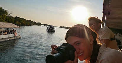 A student taking a photograph on a boat trip