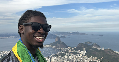 A student looking down from a mountain to the city below